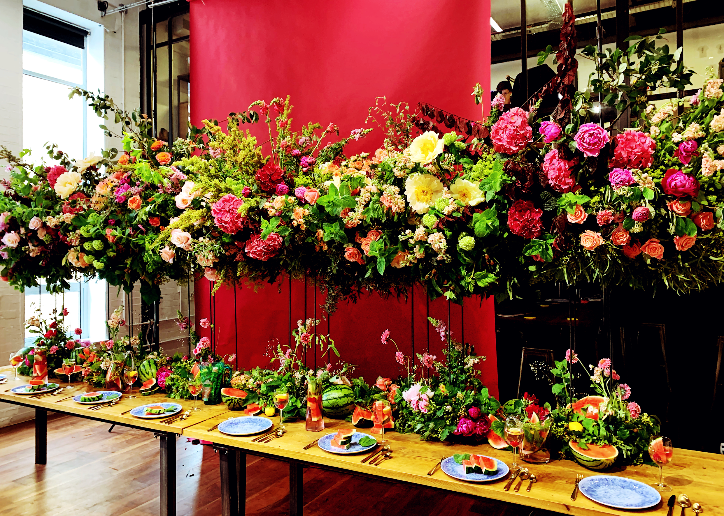 Long table arrangement against a red wall