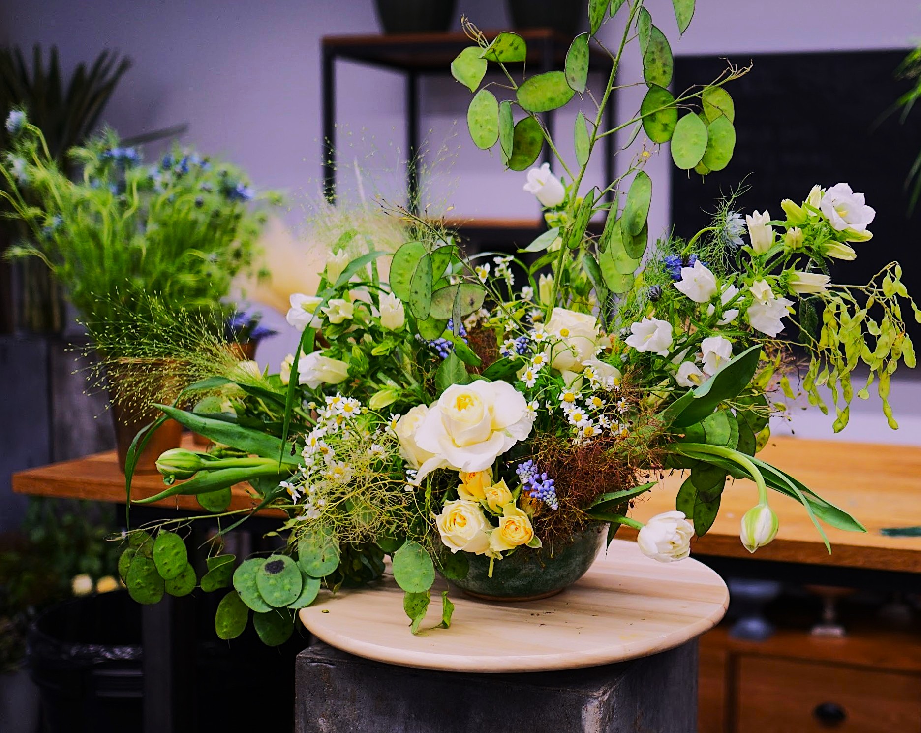Garden-style arrangement with lunaria and yellow roses in a bowl